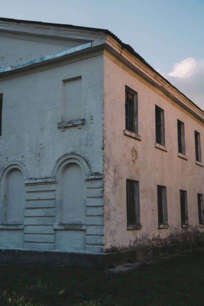 istock Boarded-up windows of an old abandoned building. Evening sunlight 2182153997