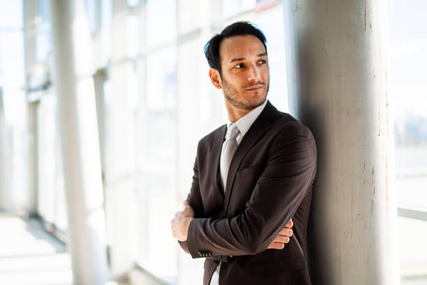 istock Pensive businessman leaning against pillar in modern office 2182154677