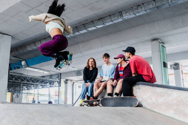 istock Skaters skating with friends on a skateboard park 2182154807
