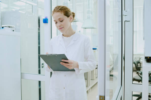 istock Scientist Wearing Lab Coat Holding Clipboard Smiling Confidently 2182154882