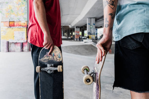istock Midsection of skaters holding skateboarding on a skateboard park 2182155067