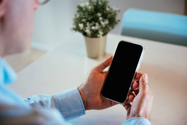 istock Businessman in blue shirt holding smart phone with blank screen 2182157514