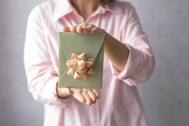 istock female hands holding a gift certificate, gift voucher or discount 2182159384