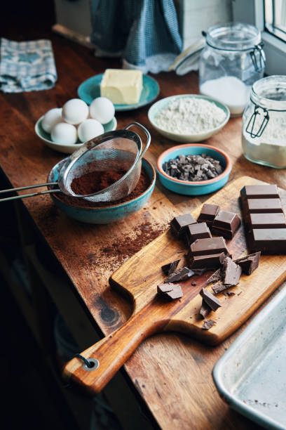 Woman hands making chocolate mousse and cookies on a wooden table in a rustic kitchen
