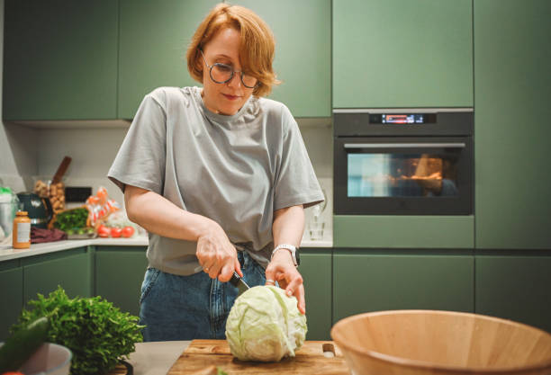 istock woman preparing salad in the kitchen 2182161350