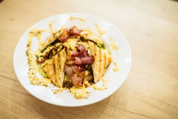 A mouthwatering bowl of grilled chicken salad topped with crispy bacon, drizzled with creamy dressing.
