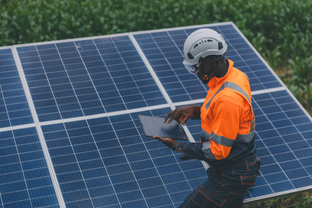 istock Engineer Checking solar panels in agriculture farm land. Engineer examining solar panels at field. Technicians maintenance solar photo voltaic panels  in agriculture farm field. clean energy 2182168791