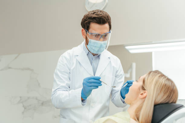 istock Dentist examining patient teeth with dental instruments in clinic 2182169485