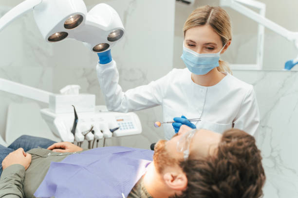 istock Dentist positioning dental light while examining patient's teeth 2182169594