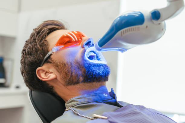 istock Patient undergoing teeth whitening procedure with uv light in dental clinic 2182170099
