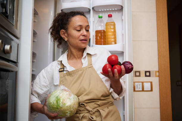 istock Woman organizing fresh vegetables in the kitchen fridge 2182171344