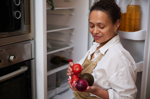 istock Woman in apron selecting fresh produce from refrigerator 2182171574