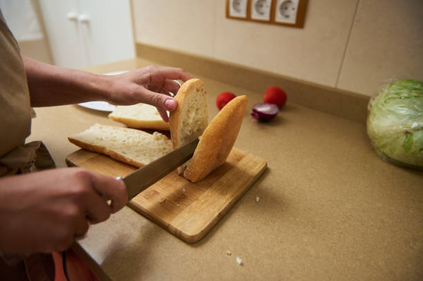 istock Person slicing bread on a cutting board in a kitchen setting 2182171684