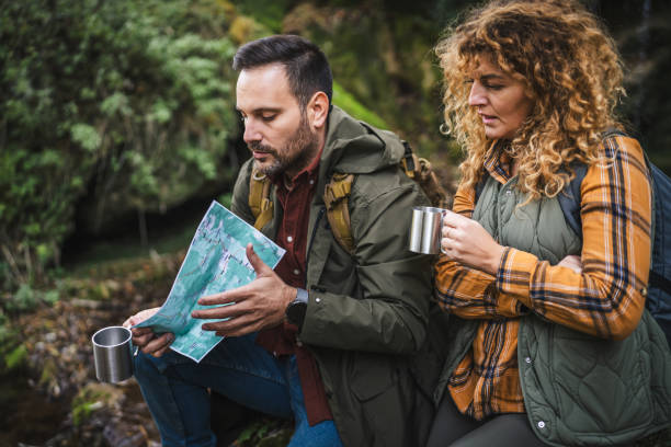 istock couple hiker backpacker hold map and cup find route on map 2182173719