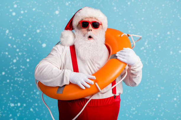 istock Photo of retired old man grey beard hold inflatable circle shock someone drowning need help unexpected wear red santa x-mas costume suspender sunglass cap isolated blue color background 2182175073