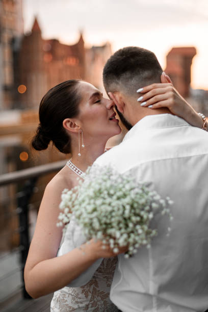 istock Focus on a smiling pretty bride whispering something gently in her groom's ear 2182180284