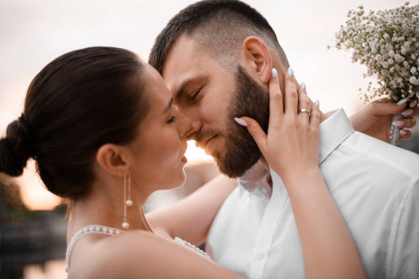 istock Bride and groom pulling their lips towards each other for kiss 2182180686