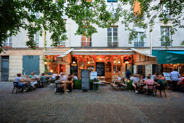 Electric bike park in front of a restaurant with tables and chairs on the sidewalk. Paris. France. December 9, 2024.