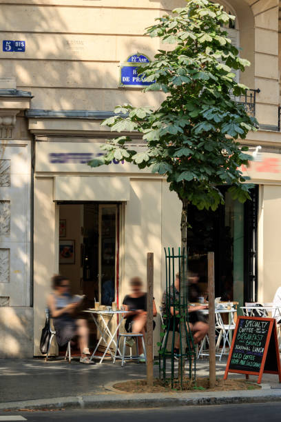 Paris, France\nFebruary 2017\nCurly hair woman , seen through Cafe Window with ornamented red lettering. Reflections on the glass show street ooutside and cafe inside.