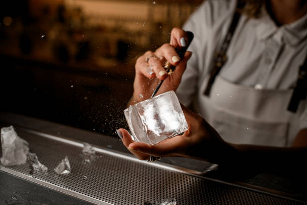 istock Female bartender hands holding an ice cube and chipping pieces of ice 2182182148