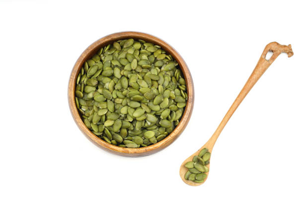 istock Pumpkin seeds in a wooden bowl on a white background 2182184739