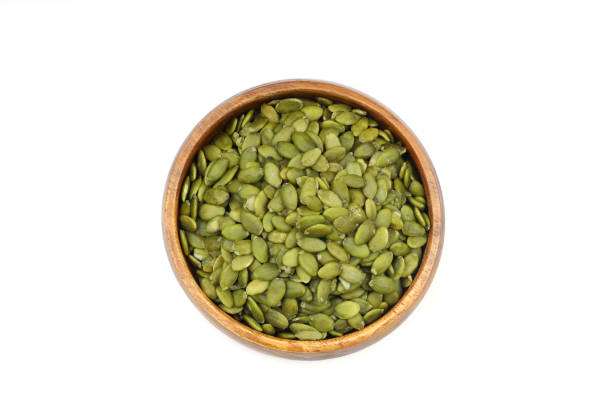istock Pumpkin seeds in a wooden bowl on a white background 2182184740