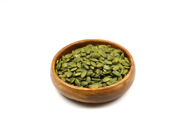 istock Pumpkin seeds in a wooden bowl on a white background 2182184750
