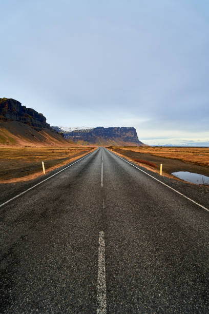 istock Straight road leading to mountains in iceland 2182186266