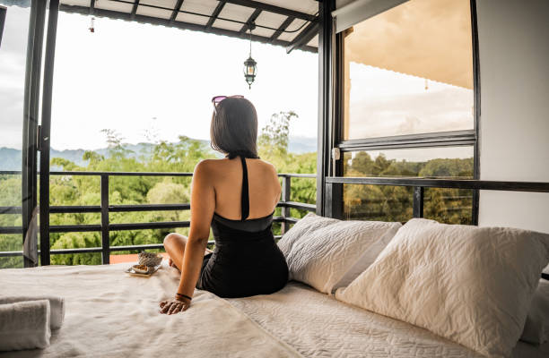 istock young woman on her back sitting on the bed 2182195420