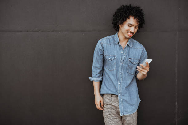 istock Man smiling at phone, casual look 2182200998