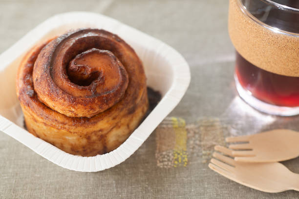 istock take away cinnamon bun in paper cup with glass reusable coffee cup. 2182209536