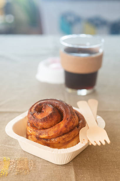 istock take away cinnamon bun in paper cup with glass reusable coffee cup. 2182209568