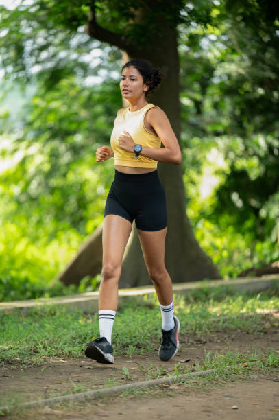 istock Athlete woman running in public park 2182212759