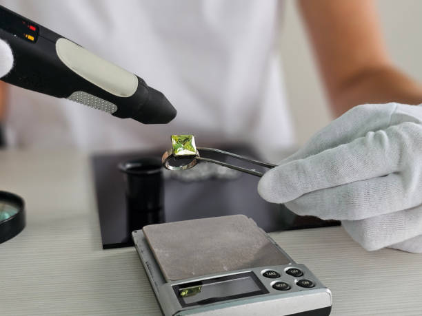 istock Gemologist examining a green gemstone with a laser 2182213492