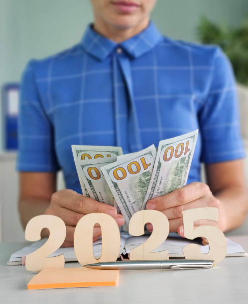 istock Person handling cash while planning finances for the year 2025 2182213708