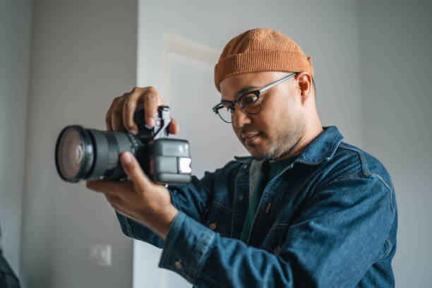 Professional man photographer working shooting woman model using digital camera and flash studio in studio on white background. photography concept.