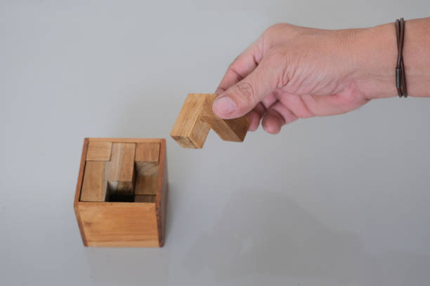 Close up shot of isolated hand playing with wooden cube puzzles