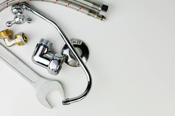 istock A wrench is currently laying on a pristine white surface adjacent to a faucet 2182221664