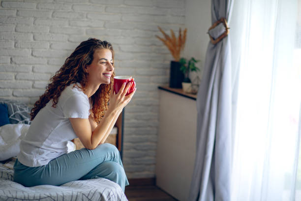 istock Woman drinking coffee in bed in the morning 2182222599