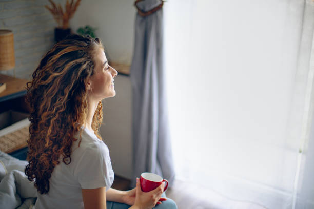 istock Beautiful woman enjoying the morning while drinking coffee 2182223526