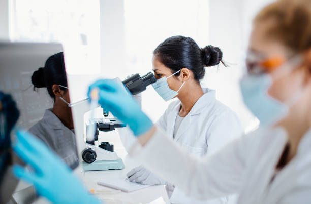 istock Indian Female Scientist Examining Microscope Slides in Laboratory 2182230085