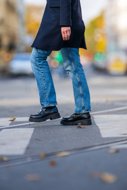 istock Person crossing a road with tram tracks.. 2182232130