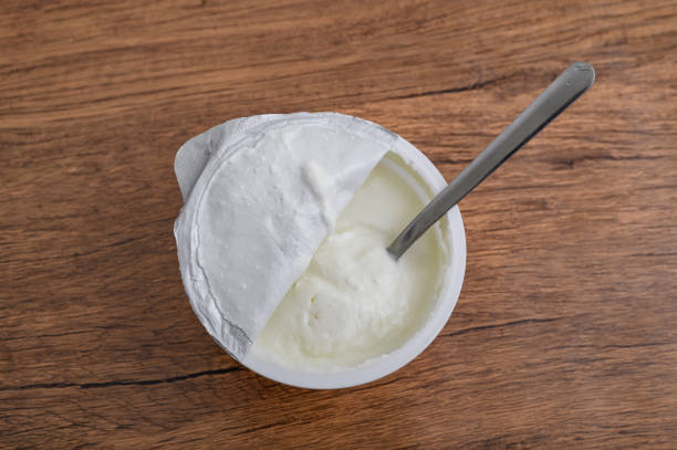 istock Sour cream in a plastic insulated container stands on the table 2182232168