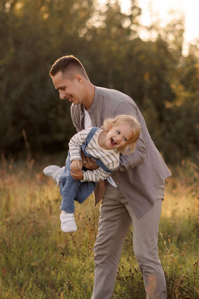 istock Father holding happy child on summer walk in park. 2182234635