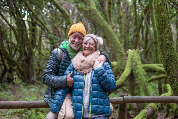 istock Affectionate active senior couple embrace in the forest, mossy tree branches in Garajonay National Park on La Gomera Island. Healthy lifestyle in retirement 2182237703