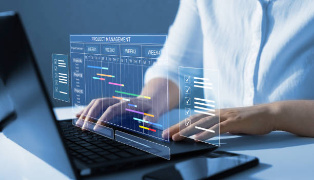 istock Business Project Management System.Project manager working on laptop and updating tasks and milestones progress planning with Gantt chart scheduling interface for company on virtual screen. 2182242380