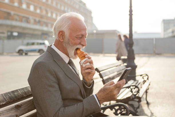 istock Businessman Taking a Break Outdoors, Checking Phone on City Bench 2182242626