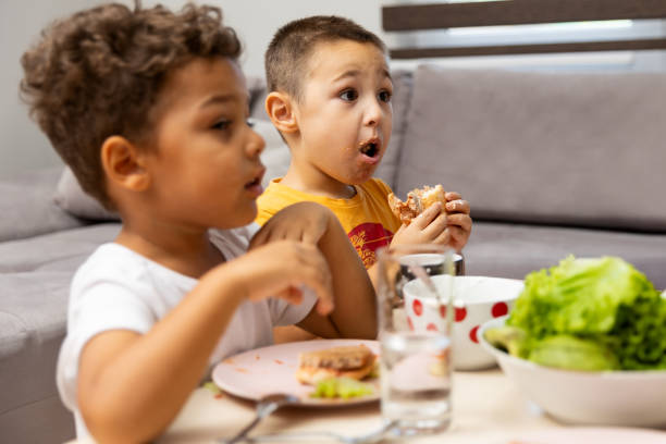 istock Two Kids Enjoying a Meal Together at the Table 2182246289
