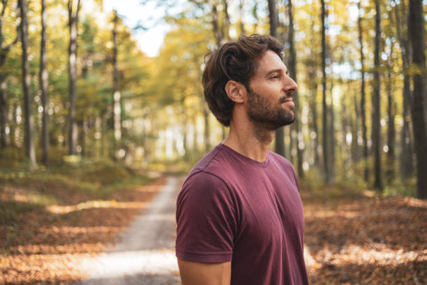 istock Side view portrait of smiling man standing in the forest 2182247697