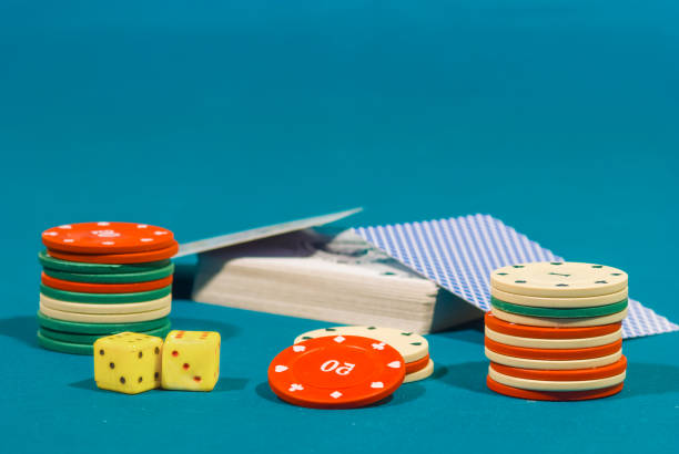 Colorful poker chips with 25, 10 and 5 callouts placed on pack of cards showing gambling, rummy teen patti often played on diwali and new year